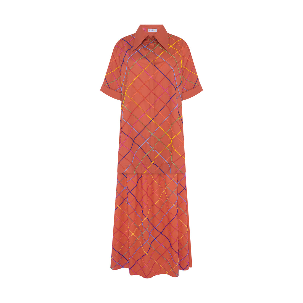 Still do conjunto completo Vera Listras laranja em tricoline de algodão, com camisa e saia longas bordadas à mão em miçangas multicoloridas.