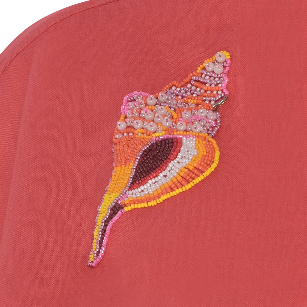 Detalhe do bordado de concha em miçangas e linha de algodão, realçando o trabalho artesanal do Vestido Yas Conchas.