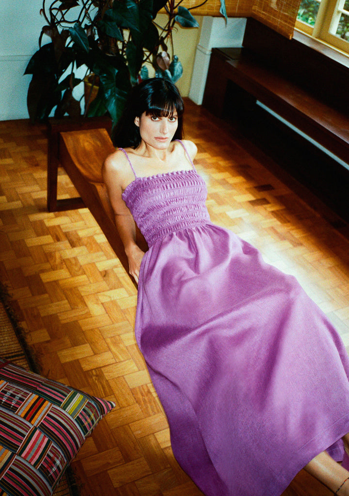 Modelo usando o vestido Beatriz lilás em linho 100% com bordado manual em miçangas nas alças e saia ampla fluida.