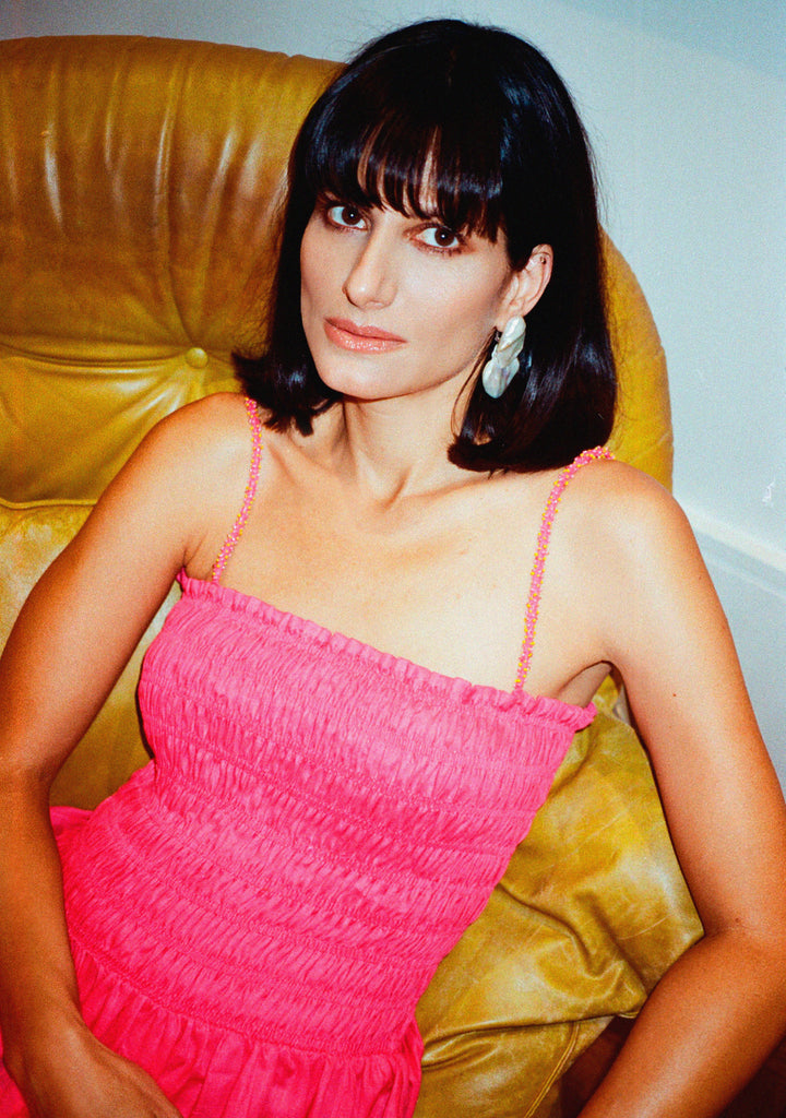 Modelo usando o vestido Beatriz rosa em linho puro com lastex no busto e cintura e alças bordadas à mão com miçangas.