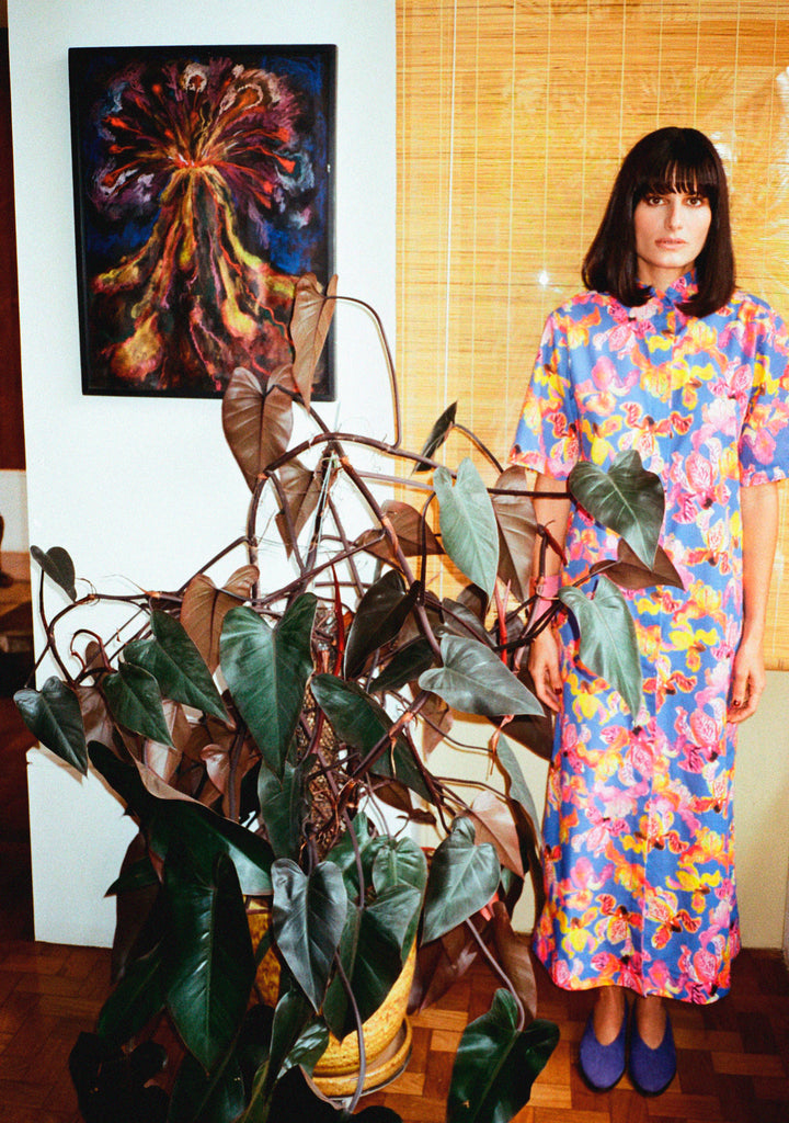 Modelo usando o vestido Yas Íris Azul em algodão com estampa floral pintada à mão em tons de rosa, verde e amarelo.