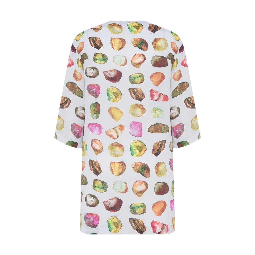 Vista traseira da túnica Yas Pedraria em chine due com caimento fluido e estampa aquarelada multicolorida.